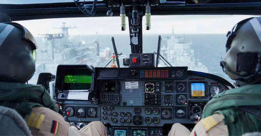 Abb. 2:  Piloten fliegen in einem Bordhubschrauber Sea Lynx MK 88A über die Szenerie bei einem Versorgungsmanöver zwischen zwei Marineschiffen