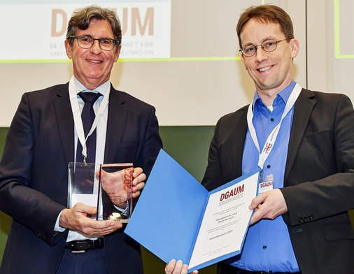 Priv.-Doz. Dr. Stefan Karrasch (rechts) bekommt von Prof. Thomas Kraus (links) den Innovationspreis der DGAUM überreicht