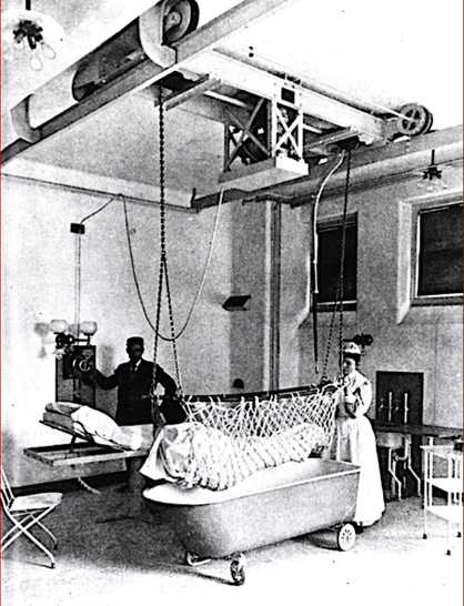 Abb. 1:    Schwester und Kran﻿kenträger bewegen einen Patienten vom Bett in die Badewanne (1898; National Library of Medicine, zitiert nach https://www.npr.org/2015/02/04/382639199/hospitals-fail-to-protect-nursing-staff-from-becoming-patients) - © Foto: National Library of Medicine
