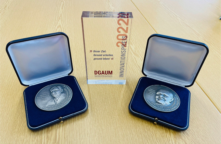 Die Auszeichnungen wurden anlässlich des 60-jährigen Jubiläums neu gestaltet: Joseph-Rutenfranz- Medaille (links), Franz-Koelsch-Medaille (rechts) und der Innovationspreis der DGAUM (Mitte)