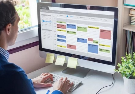 „Betriebsarzt überprüft einen digitalen Kalender mit Terminen für Arbeitsschutz-Workshops und Ergonomie-Schulungen an einem modernen Arbeitsplatz, umgeben von gesundheitsfördernden Pflanzen. - © NicoElNino – stock.adobe.com