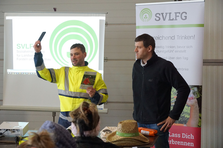 Die Web-App der SVLFG mit Erklärvideos und Informationen in der Landessprache der Saisonarbeitskräfte lässt sich über auf jedes Smartphone abrufen. Personen von links: Ernst Christian Schmidt; Thomas Hemm
