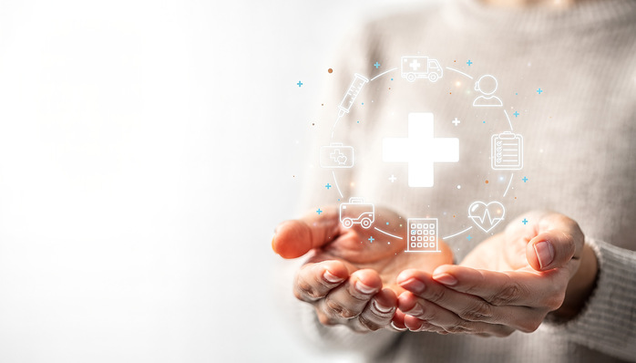 Hands holding glowing medical cross with healthcare icons, digital health insurance and medical support concept with copy space.
